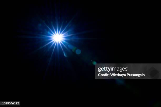 lens flare against black background - starburst stock-fotos und bilder