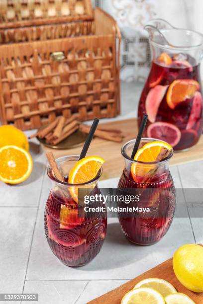 frischer sangria sommercocktaildrink mit orangen zitrone und äpfeln auf eis im krug - apfelpunsch stock-fotos und bilder