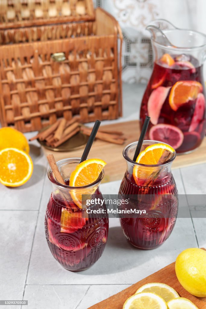 Fresh Sangria summer cocktail drink with Oranges Lemon and Apples on ice in pitcher