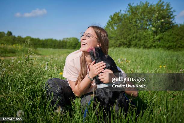 young woman embracing pet dog - dog licking stock pictures, royalty-free photos & images