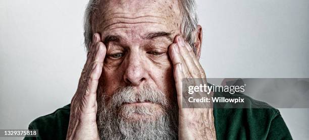 sad depressed senior adult man rubbing sides of head - tangled hair stock pictures, royalty-free photos & images