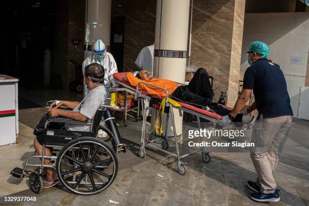 Covid19 patients are prepared to get treatment in an emergency tent at Bekasi General Hospital on July 18, 2021 in Bekasi, Indonesia. Indonesia has...