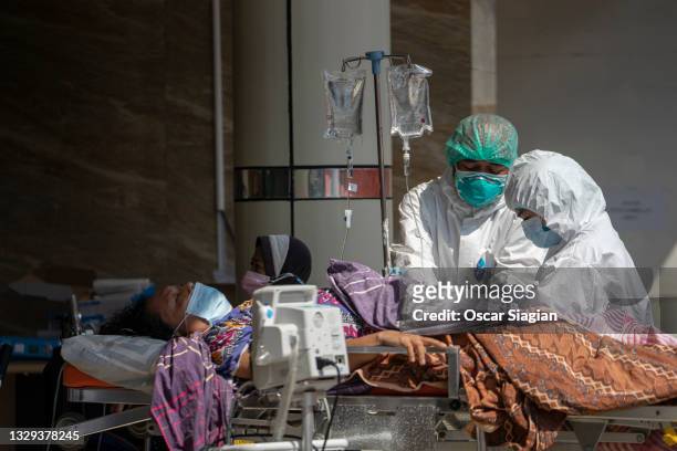 Covid19 patients get treatment in an emergency tent at Bekasi General Hospital on July 18, 2021 in Bekasi, Indonesia. Indonesia has imposed emergency...