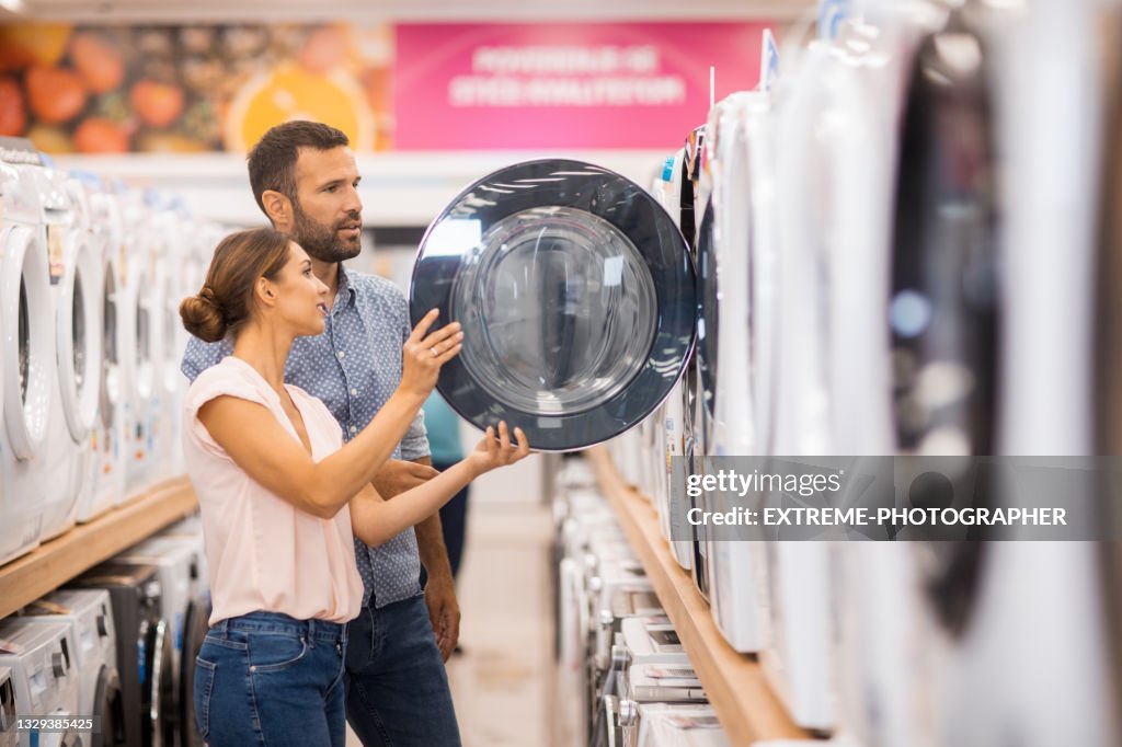 Young couple looking for a proper drying machine