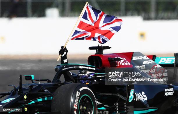 Race winner Lewis Hamilton of Great Britain driving the Mercedes AMG Petronas F1 Team Mercedes W12 waves the Union Jack to celebrate during the F1...