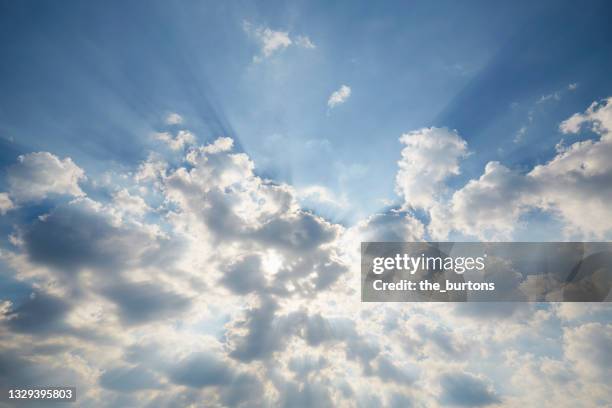 full frame shot of dramatic sky and clouds against sun, abstract background - くもり ストックフォトと画像