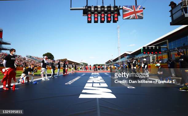 The F1 drivers stand and kneel on the grid as part of the We Race As One gesture before the F1 Grand Prix of Great Britain at Silverstone on July 18,...