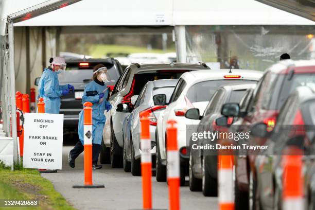 Medical staff are seen administering COVID-19 tests at a drive through testing site at Albert Park Lake on July 19, 2021 in Melbourne, Australia....