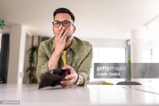 joven serio que tiene problemas financieros. - cartera fotografías e imágenes de stock
