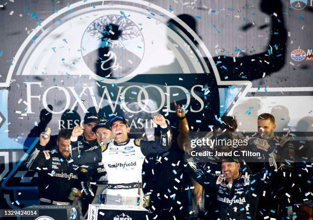 Aric Almirola, driver of the Smithfield Ford, celebrates in victory lane after winning the NASCAR Cup Series Foxwoods Resort Casino 301 at New...