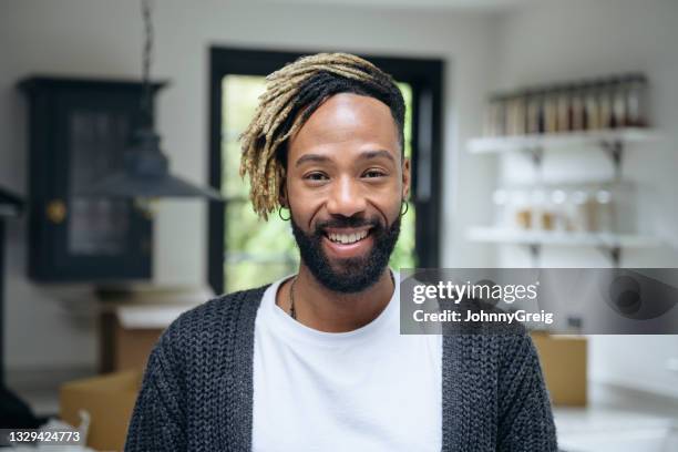 retrato en casa de un hombre negro relajado con ropa casual - corte de pelo con media cabeza rapada fotografías e imágenes de stock