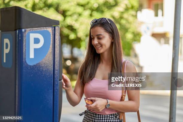 woman paying for parking with a debit card - carte bancaire voiture photos et images de collection