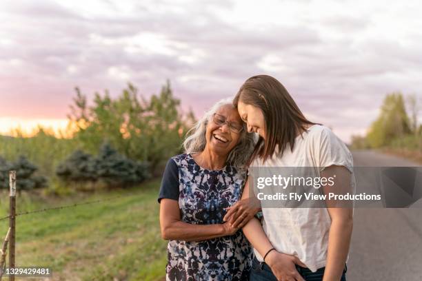 ethnic senior mother walking with her adult daughter - adult children with parents stockfoto's en -beelden