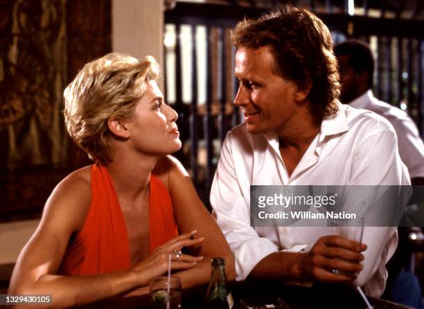 American stage and screen actress Kelly McGillis talks with American film and stage actor Peter Weller while filming a scene during the 1989 drama...