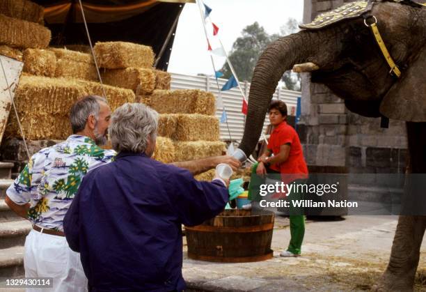 Chilean-French filmmaker and artist Alejandro Jodorowsky and a friend feed an elephant behind the scene during the 1989 drama film "Santa Sangre"...