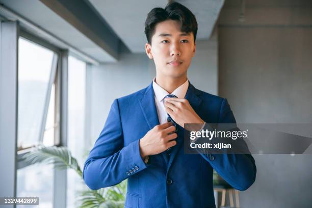 businessman dressing himself - adjusting necktie stockfoto's en -beelden