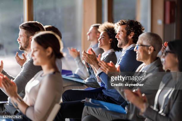 un grande gruppo di imprenditori felici che applaudono in un seminario nella sala riunioni. - riunione foto e immagini stock