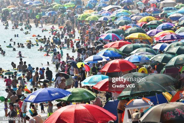 People cool off at a bathing beach on July 18, 2021 in Dalian, Liaoning Province of China.