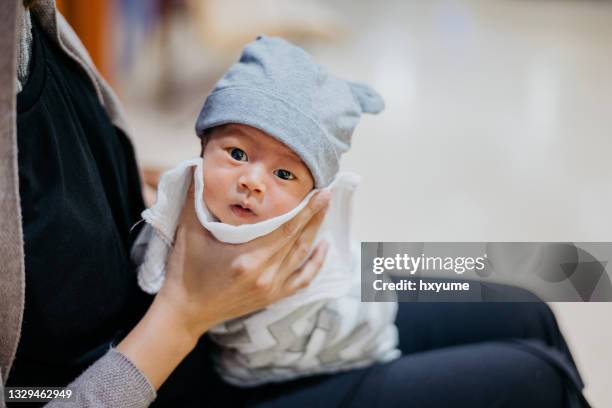 asiatische mutter rülpst baby nach der fütterung - burping stock-fotos und bilder