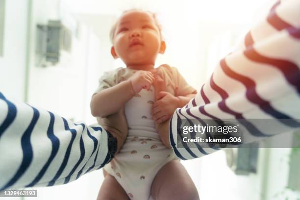 selective focus wide angle personal perspective point of view of hand  asian man lifting daughter against the sky - 2 point perspective stock pictures, royalty-free photos & images