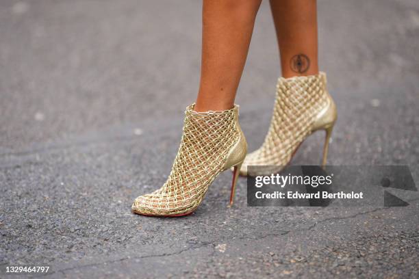 Alicia Aylies wears Louboutin golden mesh high heeled ankle shoes, on July 02, 2021 in Paris, France.