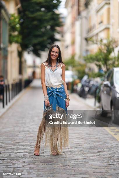 Alba Garavito Torre wears blue and silver beaded pearl necklaces, a white tank top, a pearl bracelet, a blue floral print fringed Spanish Manila...