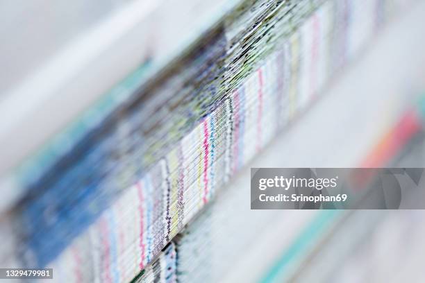 paper stack in a bin of offset printing press. - selective focus with noise and blur - printing stock-fotos und bilder
