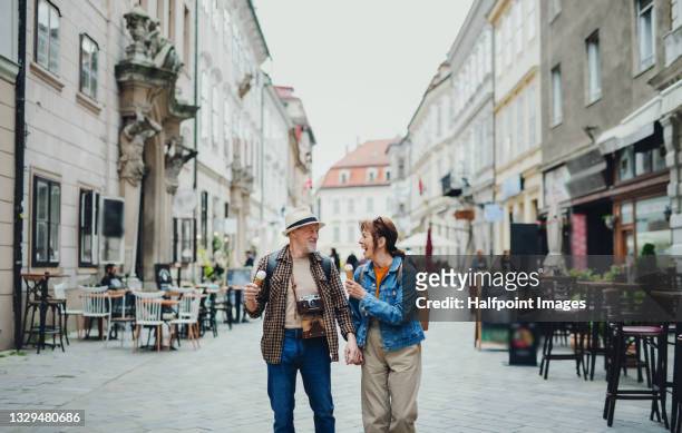 senior couple travelers sightseeing in city, eating ice cream. - slovakia town stock pictures, royalty-free photos & images
