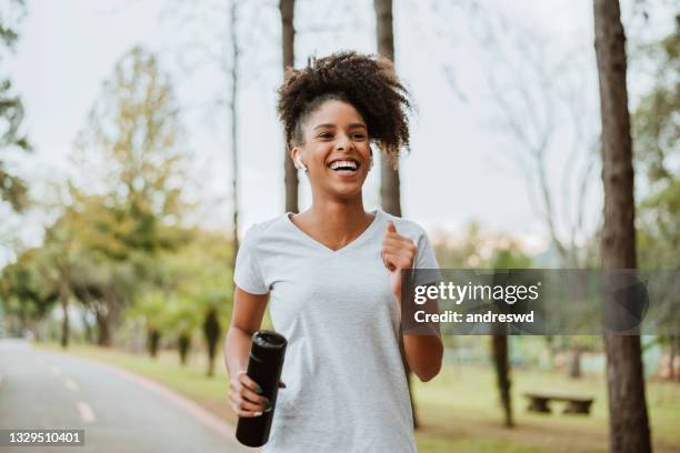 mujer corriendo en el parque - correndo fotografías e imágenes de stock