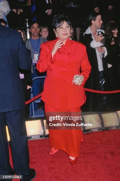 American comedian Roseanne Barr, wearing a red jacket with a full-length red skirt and red shoes, attends the 1997 American Comedy Awards, held at...