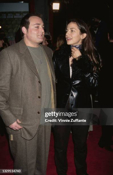 American actress Justine Bateman, wearing a black leather jacket, with an unspecified guest, wearing a grey suit, attends the premiere of 'Mars...