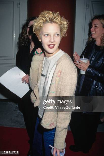 American actress Drew Barrymore, wearing a beige cardigan over a white t-shirt, attends the Westwood premiere of 'Circle of Friends' held at Cineplex...