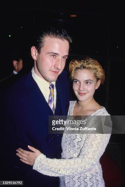 American actor David Arquette, wearing a blue suit, and American actress Drew Barrymore, in a white long-sleeve top, attend the Beverly Hills...