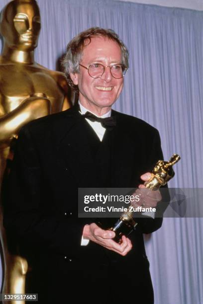 British composer John Barry , holding his Best Original Score award for 'Dances with Wolves', at the 63rd Annual Academy Awards, at the Shrine...