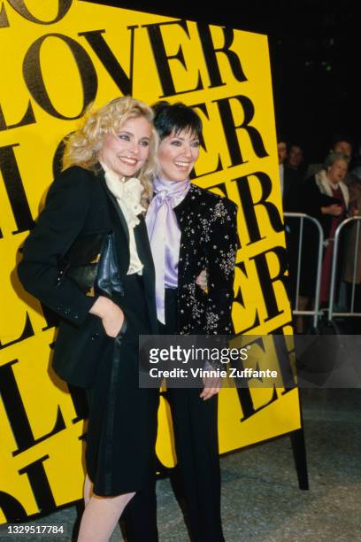 American actress Priscilla Barnes and American actress Joyce DeWitt pose in front of a yellow board on which is written 'Lover' in black, location...