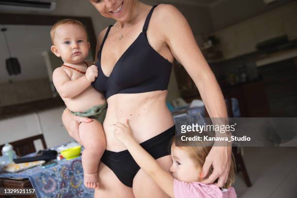 caucasian mother taking care two child - girls in bras photos 個照片及圖片檔