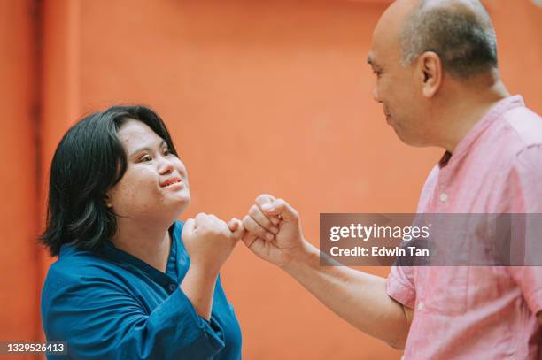 happy asian malay autism down syndrome female  pinky promise with her father in city street - pinky promise stock pictures, royalty-free photos & images