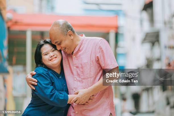 happy asian malay autism down syndrome female  bonding  with her father in city street - developmental disability 個照片及圖片檔