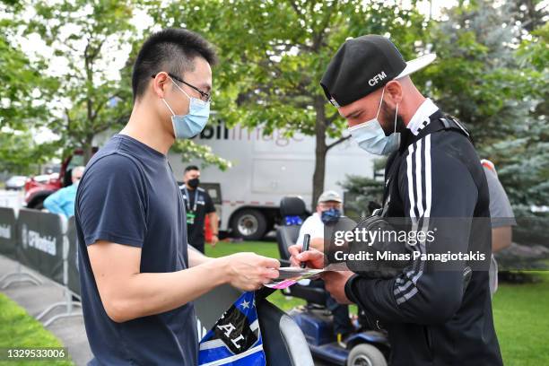 Assistant coach of CF Montreal Laurent Ciman signs an autograph for a fan prior to the MLS game against FC Cincinnati at Saputo Stadium on July 17,...
