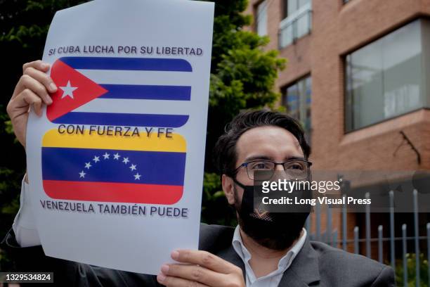 Demonstrator holds a sign with Venezuela's flag and Cuba's flag that reads 'If Cuba fights for its freedom, with strength and faith Venezuela will...