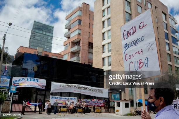 Demonstrators wave Cuban flags and hold a sign that reads 'Stop the economic blockade on Cuba' as Cuban residents that live in Colombia protest...