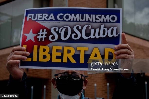 Demonstrator holds a sign that reads 'No more comunism S.O.S Cuba, Freedom' as Cuban residents that live in Colombia protest against the unrest and...