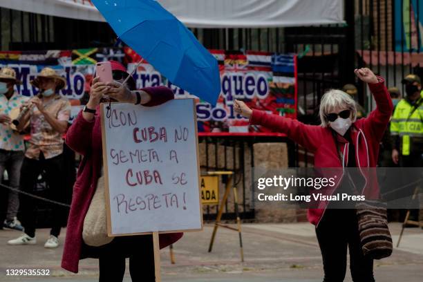 Demonstrators hold a sign that reads 'Don't mess with Cuba' as Cuban residents that live in Colombia protest against the unrest and violence held in...