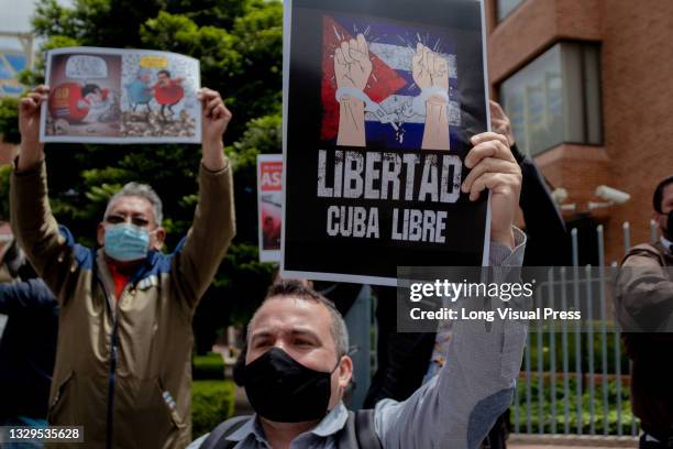 Demonstrator hold a sign that reads 'Freedom, free Cuba' as Cuban residents that live in Colombia protest against the unrest and violence held in the...