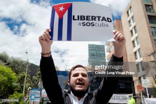 Demonstrator holds a sign with the Cuban flag that reads 'Freedom S.O.S Cuba' as Cuban residents that live in Colombia protest against the unrest and...