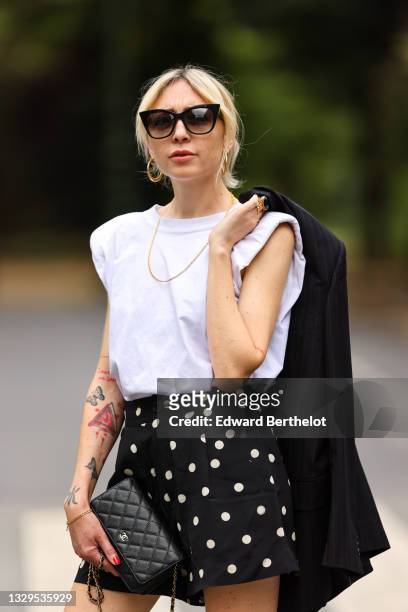 Emy venturini wears sunglasses from Dita Eyewear, earrings, a black oversized blazer jacket from Prada, a white t-shirt from The Frankie Shop, a...