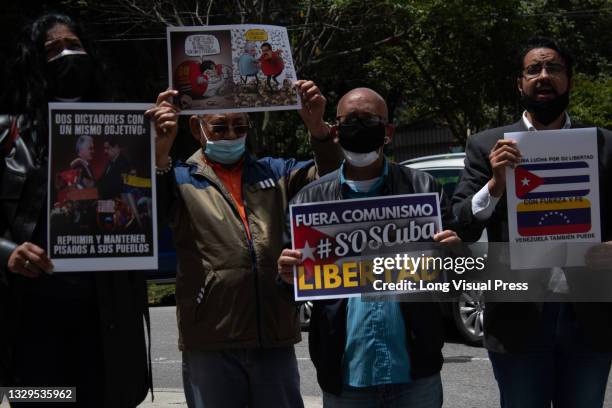 Various demonstrators hold signs in protest against Cuba's violent unrest due to protests as Cuban residents that live in Colombia protest against...