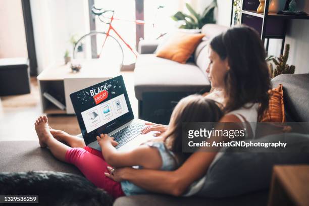 mãe e filha comprando online para tecnologia em uma venda da black friday - black friday shopping - fotografias e filmes do acervo