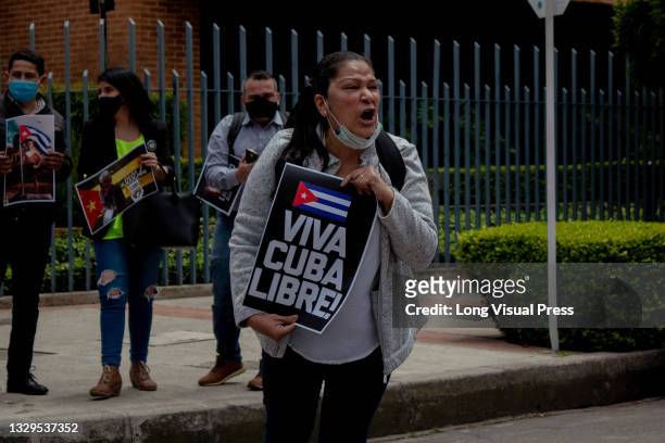 Woman shouts as she holds a sign that reads 'Freedom to Cuba' as Cuban residents that live in Colombia protest against the unrest and violence held...