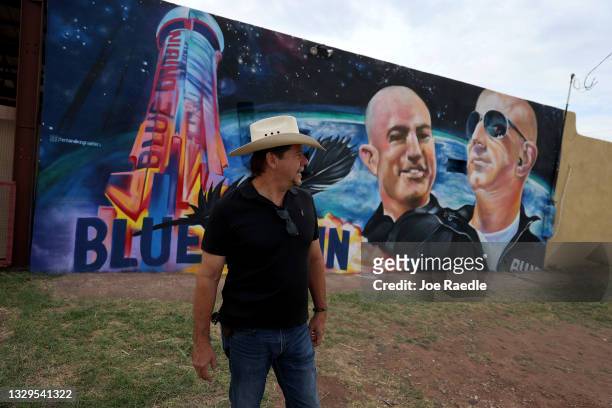 David Morales stands near a mural on the side of his building he had painted to honor Jeff Bezos as the billionaire plans to launch his Blue Origin...